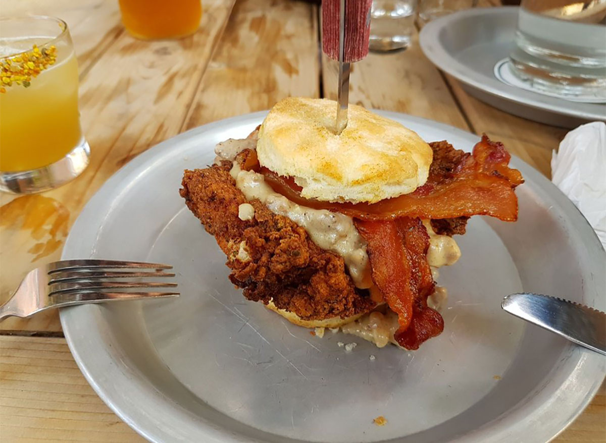 fried chicken biscuit sandwich with gravy and bacon