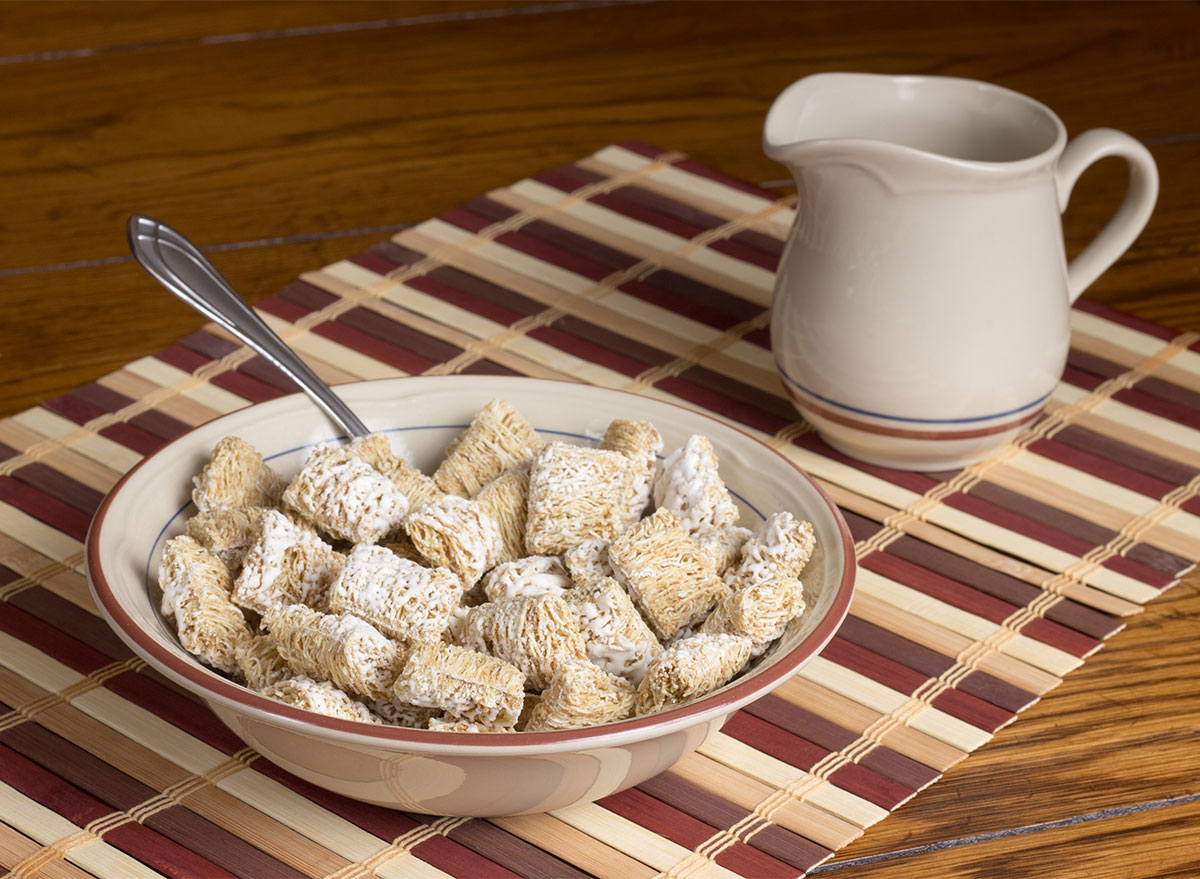 bowl of mini wheats cereal with pitcher of milk