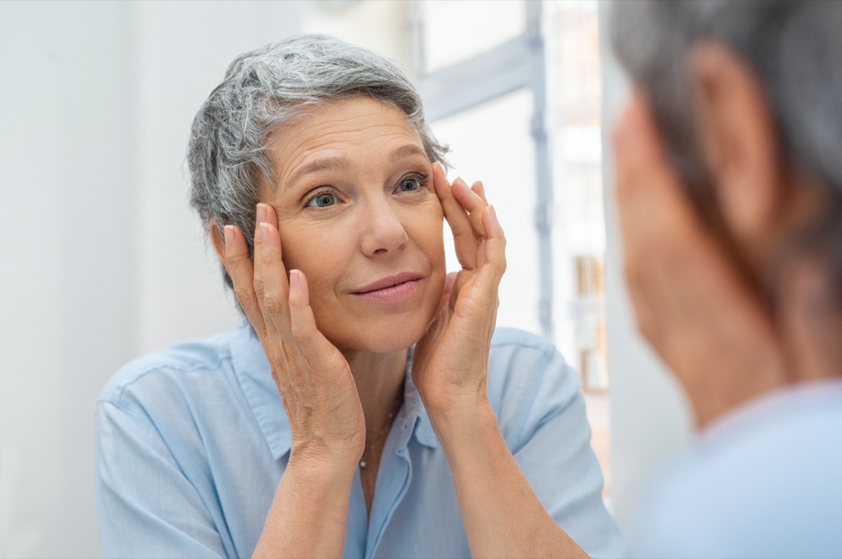 woman checking her face skin and looking for blemishes