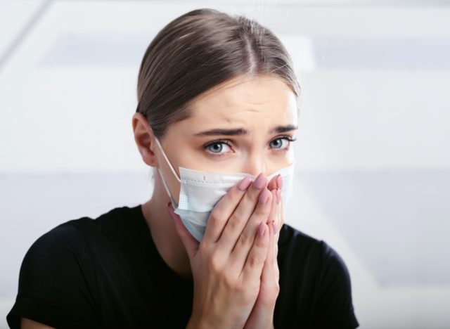 sick with a new coronavirus coughs in a disposable facial mask