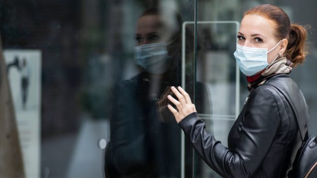 Woman at the entrance to a closed clothing store.