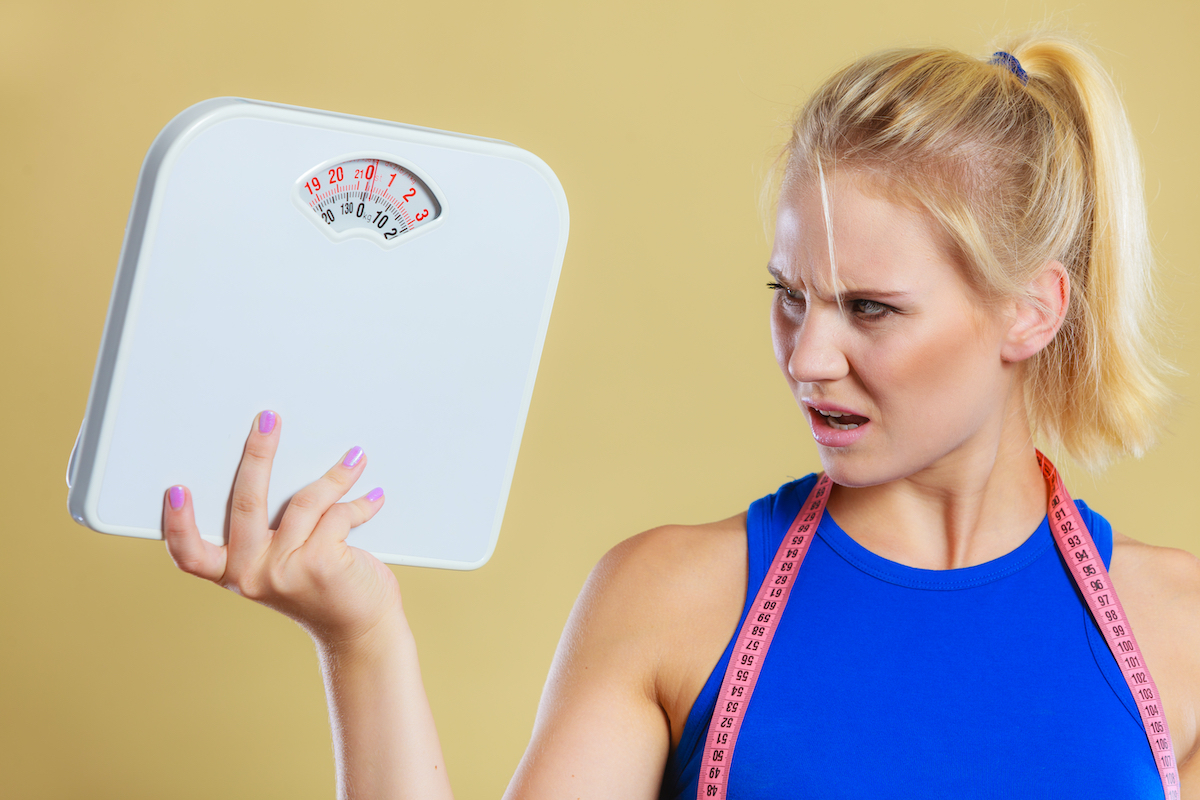 woman frustrated and angry about her scale and weight loss