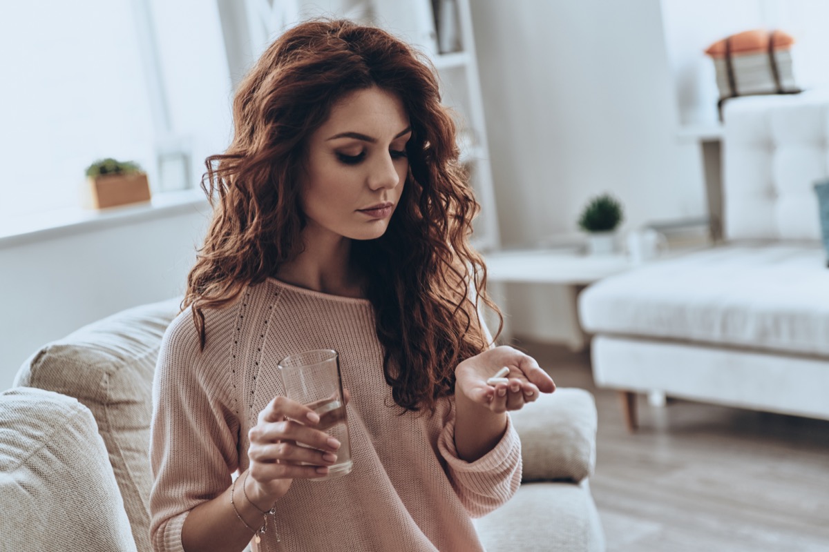 Woman holding pills on her hand.