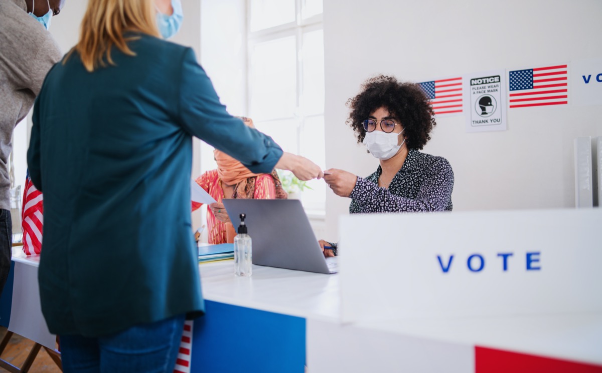 People with face mask voting in polling place, usa elections and coronavirus.