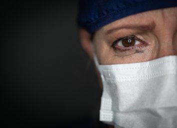 Tearful Stressed Female Doctor or Nurse Wearing Medical Face Mask.