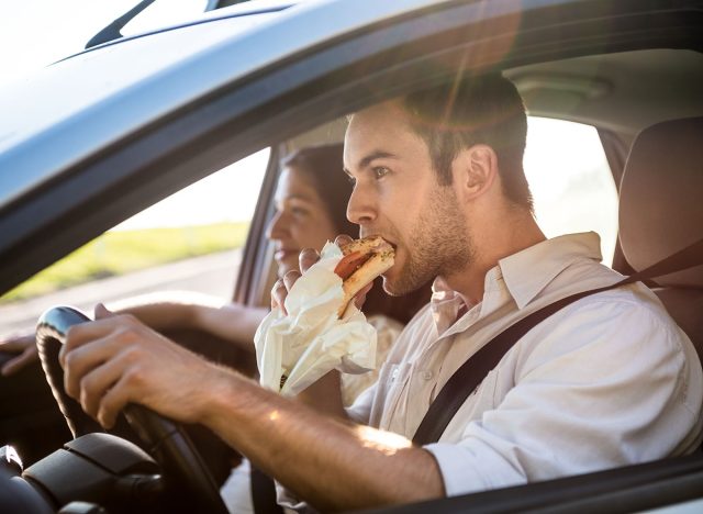man eating in car