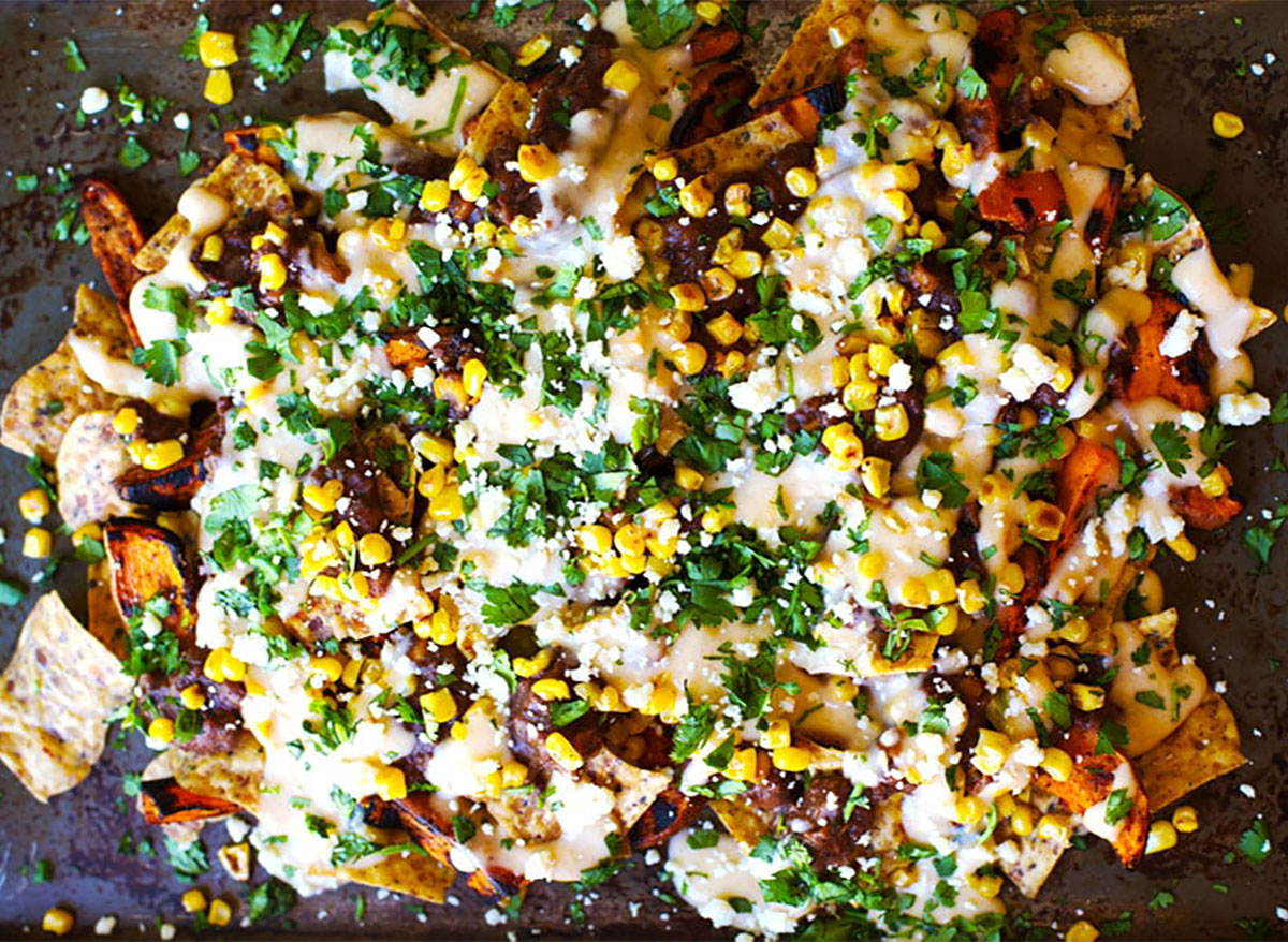 plate of nachos with cheese corn and sweet potato wedges