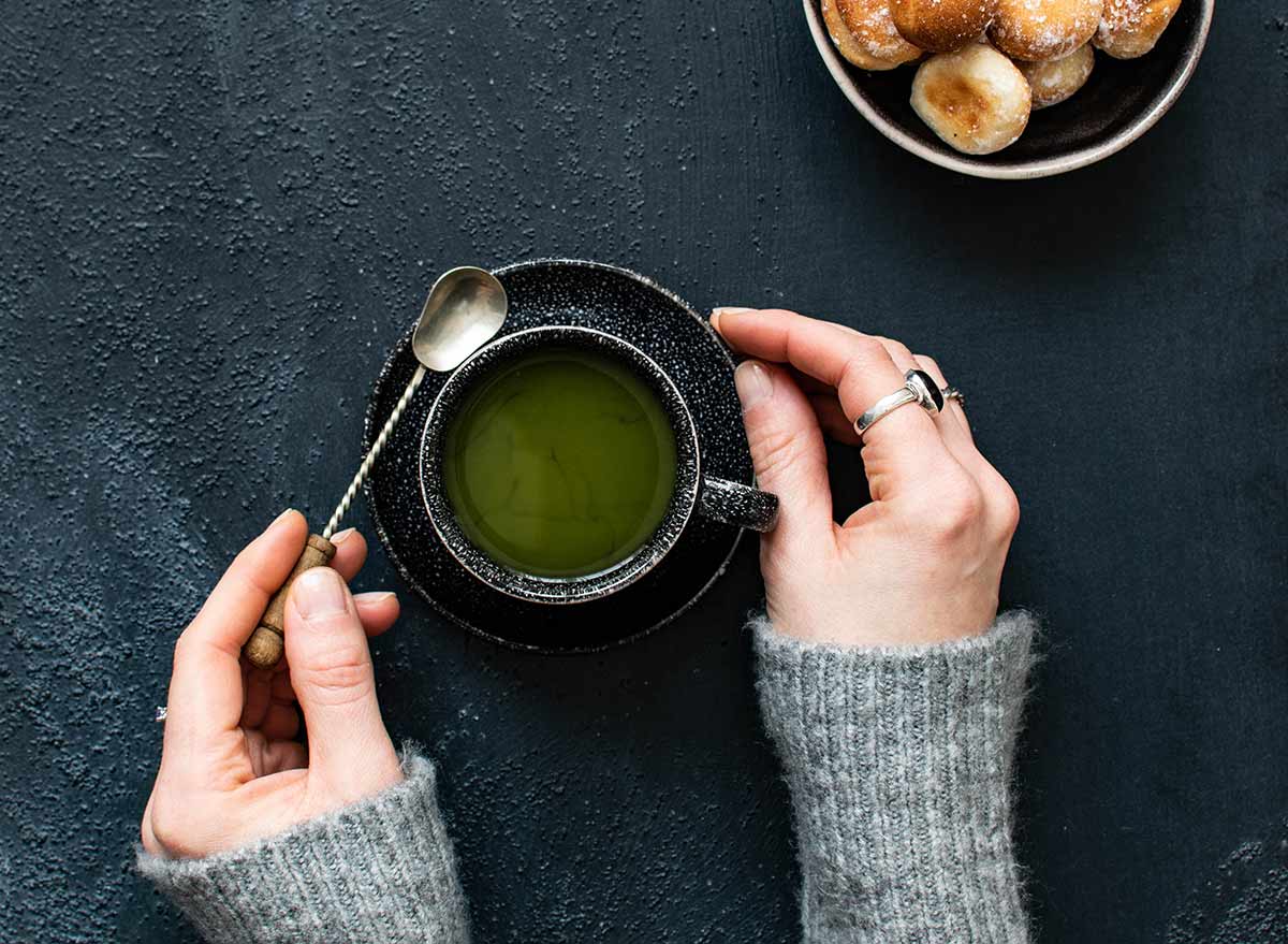 holding a cup of green tea