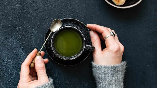 holding a cup of green tea