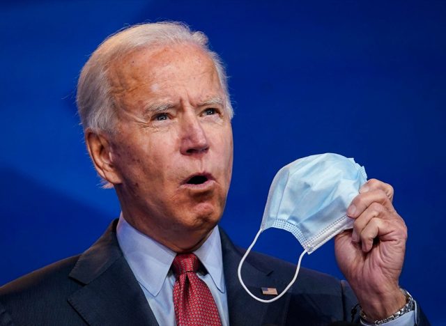 Joe Biden holds up a face mask while giving remarks about the Affordable Care Act and Covid-19.