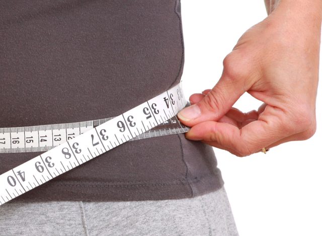 man measuring waist weight loss