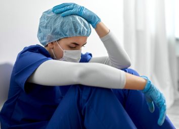 sad young female doctor or nurse wearing face protective mask for protection