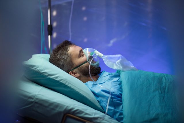 Paciente infectado en cuarentena acostado en la cama en el hospital