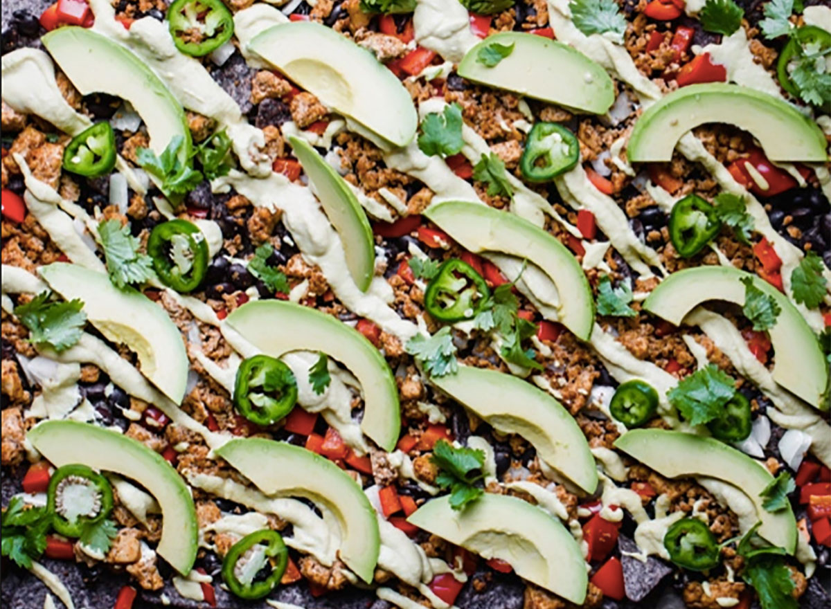 vegan nachos topped with avocado and jalapeno