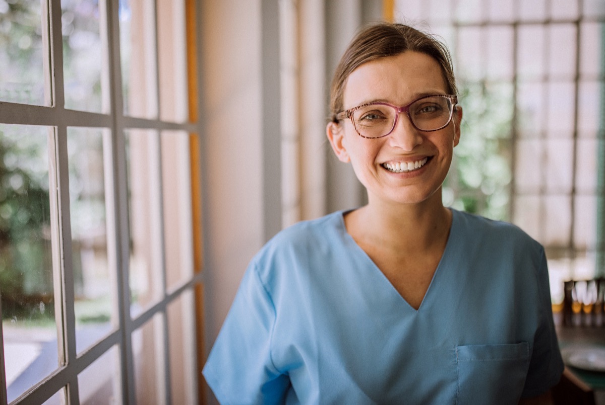 Smiling female nurse in medical scrubs.