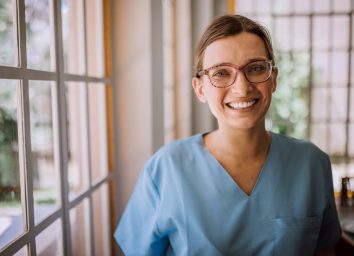 Smiling female nurse in medical scrubs.