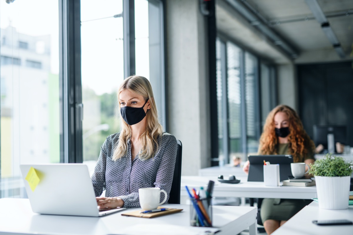 people with face masks back at work or school in office after lockdown