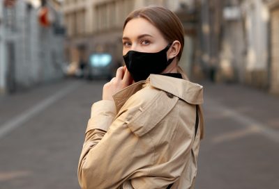 Woman wearing coat during walk on an empty street.