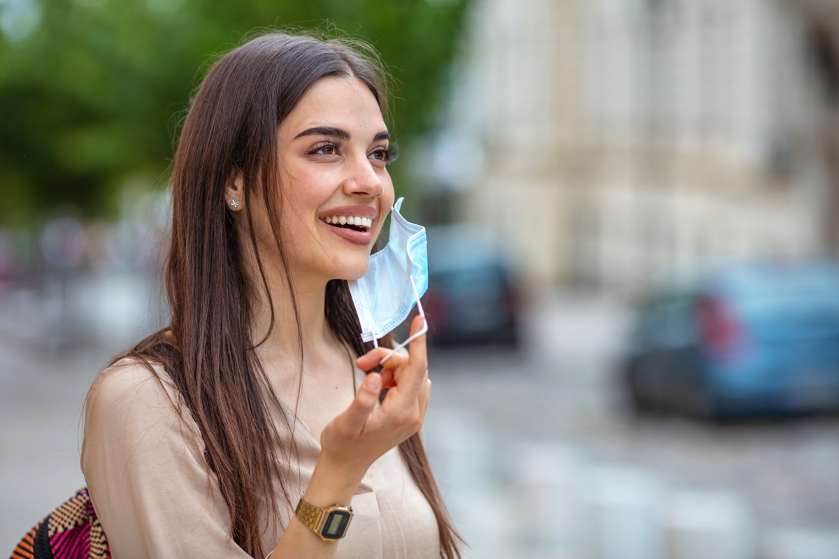 Woman taking off mask outdoor