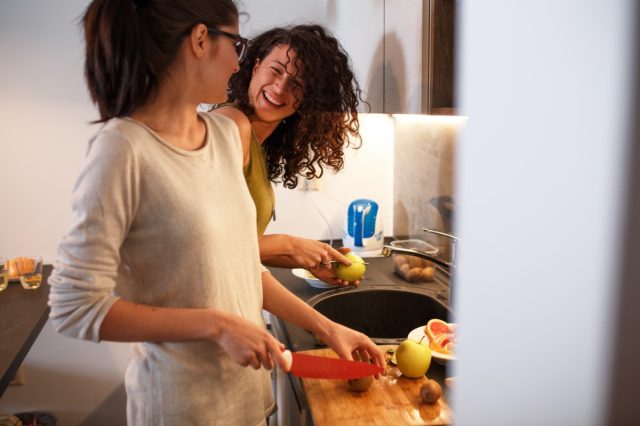 female friends in kitchen preparing together vegetarian meal