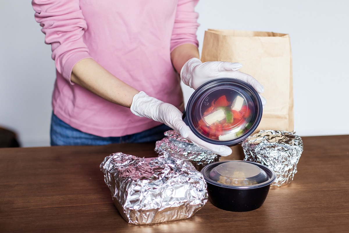 woman at kitchen home unpacks packing safely dinner