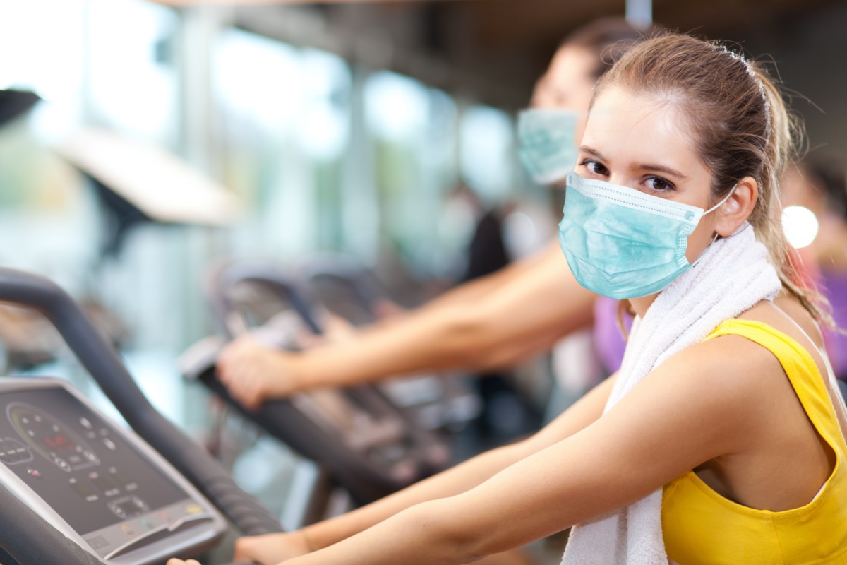 Group of people doing fitness in a gym wearing a mask, coronavirus concept