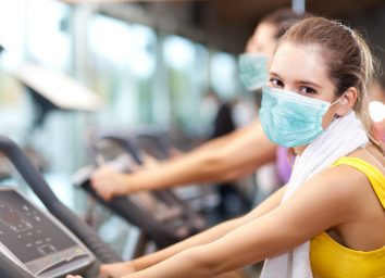 Group of people doing fitness in a gym wearing a mask, coronavirus concept