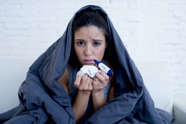 woman lying sick at home couch