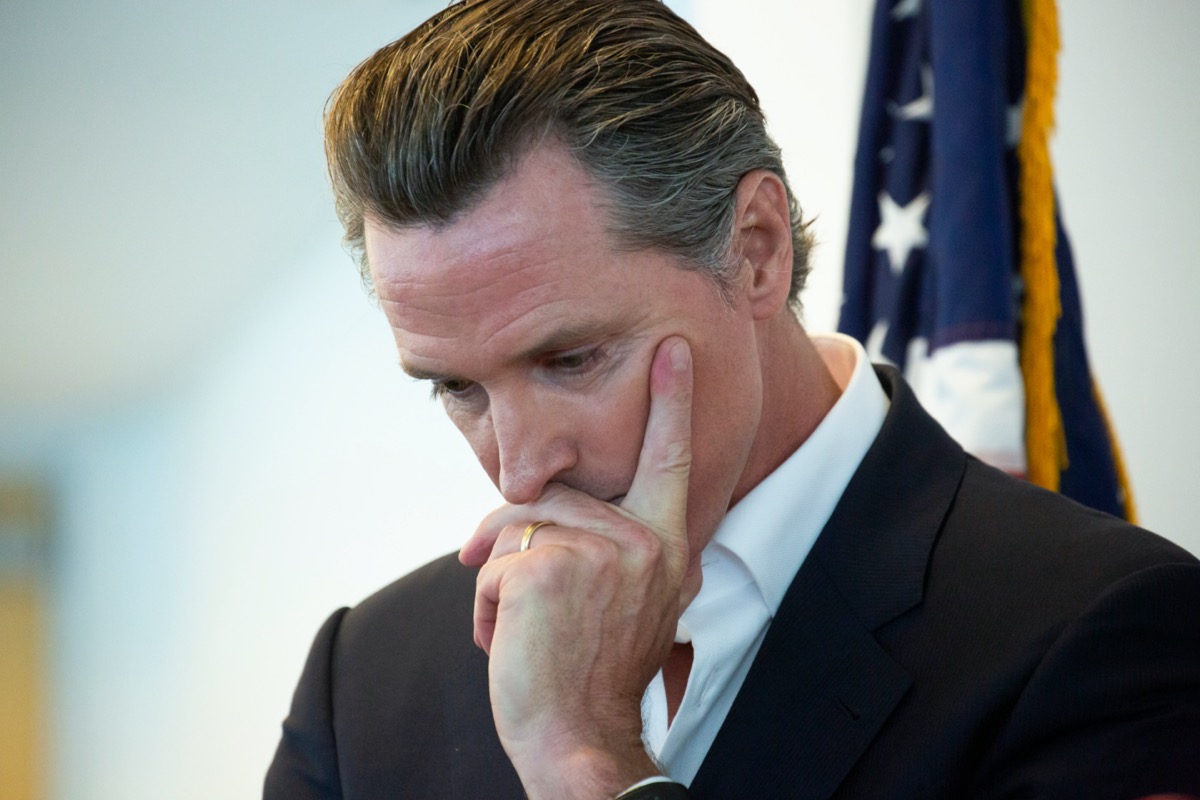 California State Governor Gavin Newsom holds his head in though before a meeting