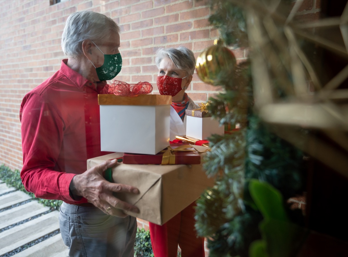 Grandparents wearing facemask and arriving home with Christmas presents