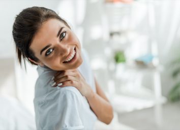 beautiful smiling girl looking at camera in bedroom in the morning