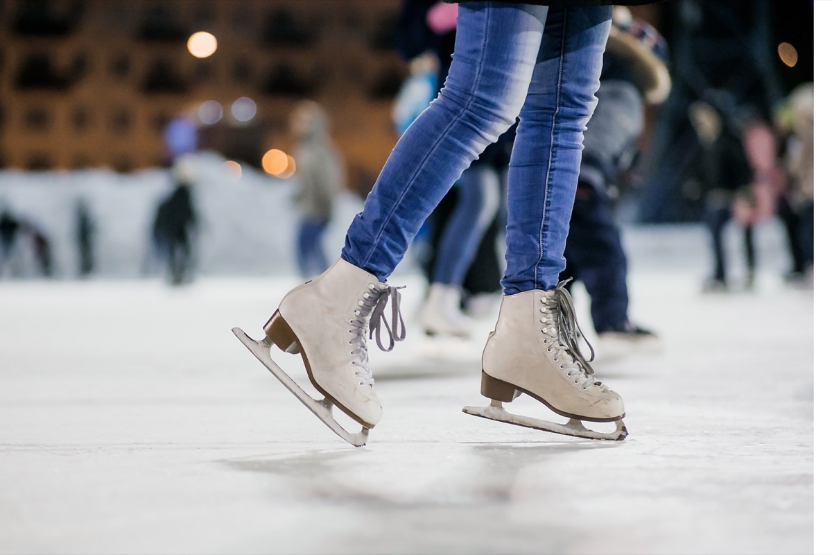 Woman on the figured skates at opened skating rink