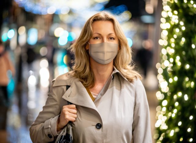Woman wearing a facemask while shopping for Christmas in London