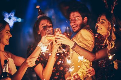 Group of friends having fun and holding sparklers at New Year's party