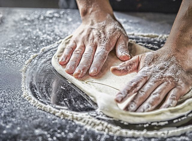 spreading pizza dough
