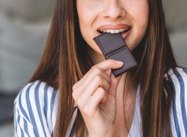 woman eating bite of chocolate bar
