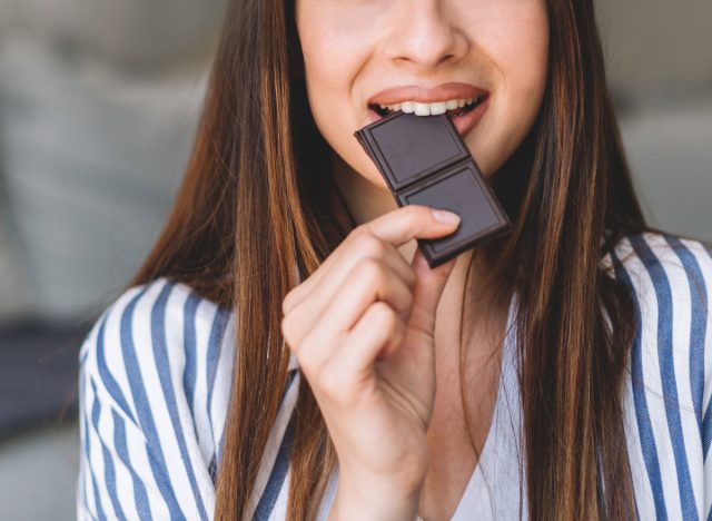 femme mangeant une bouchée de barre de chocolat