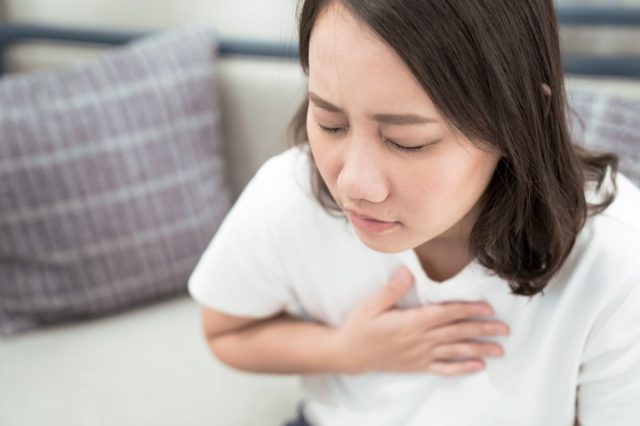 Woman puts her hand on her chest.