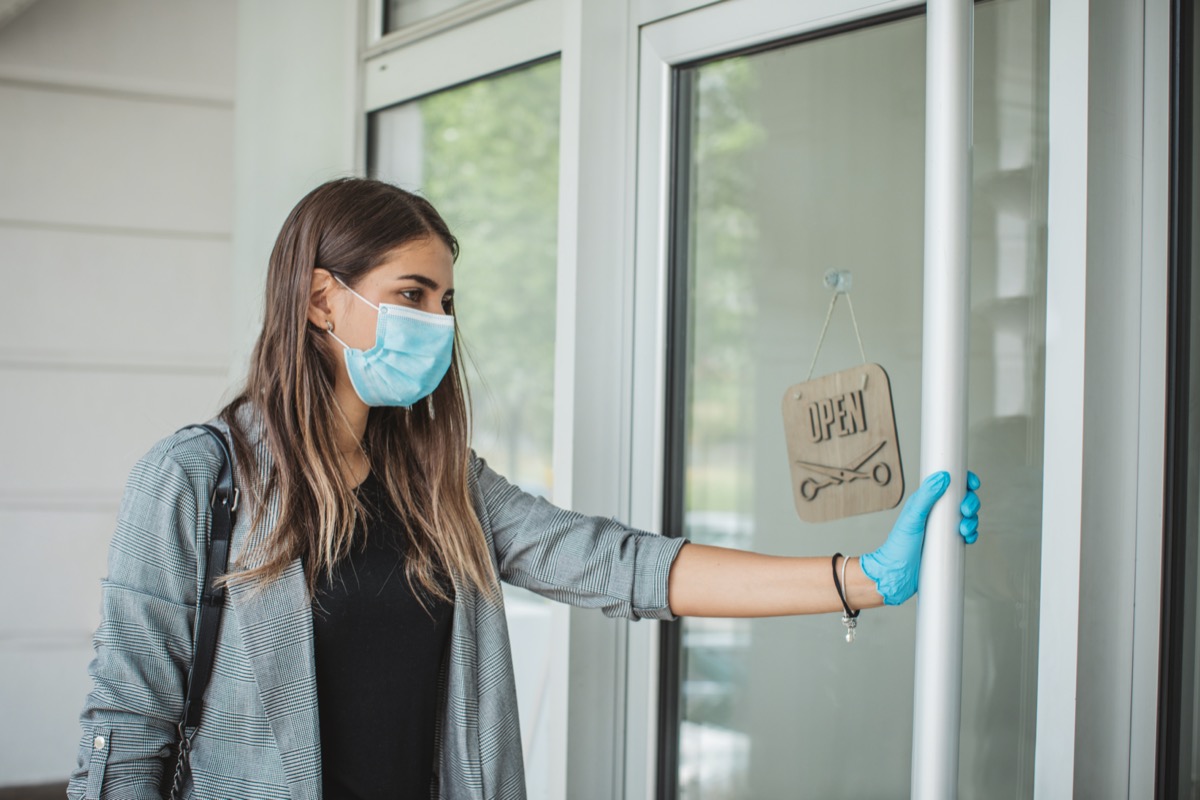 Young woman coming to hair stylist during pandemic isolation, she wears protective equipment