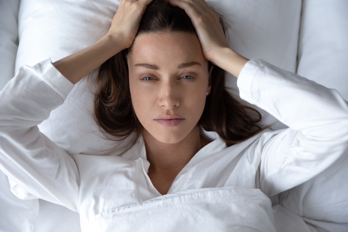 Disturbed woman lying awake in bed suffer from insomnia headache