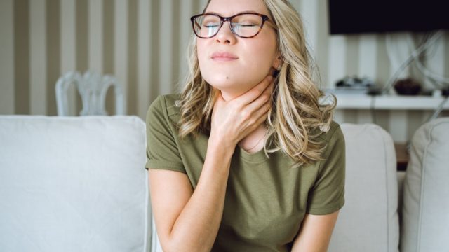Woman with sore throat at home