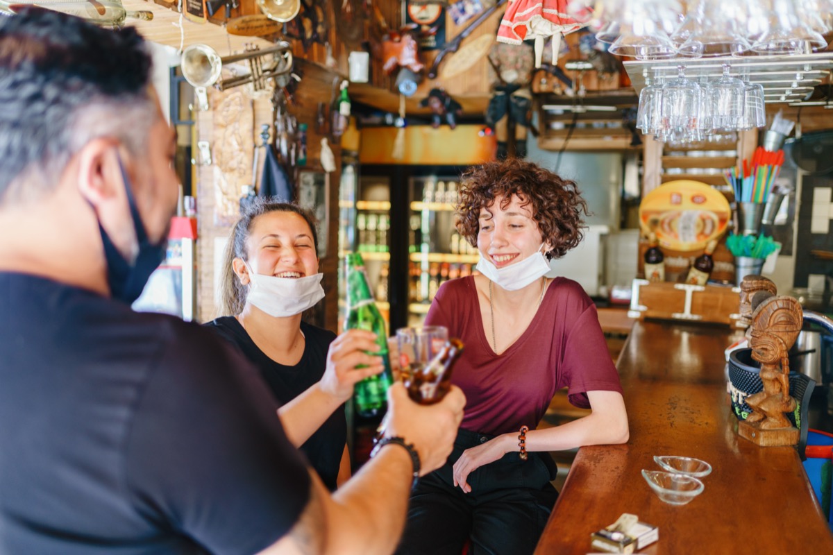 La gente aplaude con cerveza en el bar.