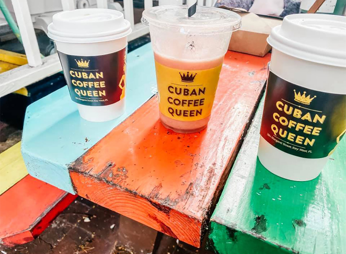 hot and iced coffee cups on rainbow painted picnic bench