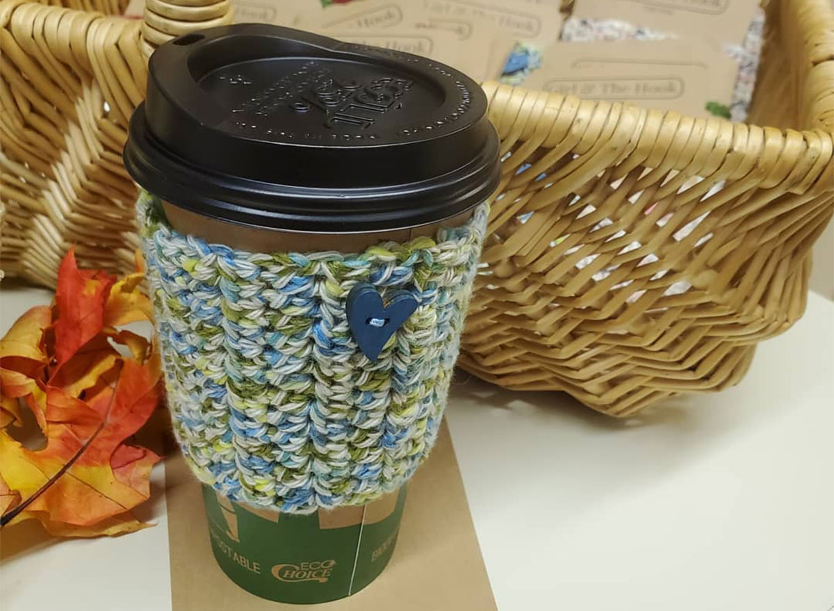 coffee with knitted sleeve in front of basket