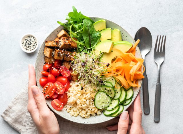 Healthy vegetarian vegan platter, tomato, carrot, avocado, brown rice, cucumber, leafy greens
