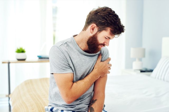 A man experiencing discomfort in his upper arm