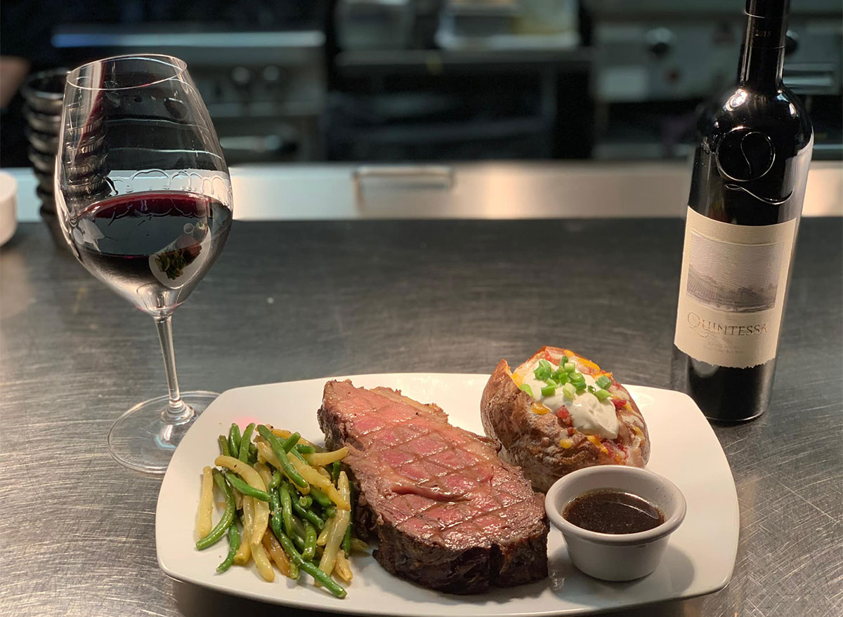 steak and baked potato with glass of wine