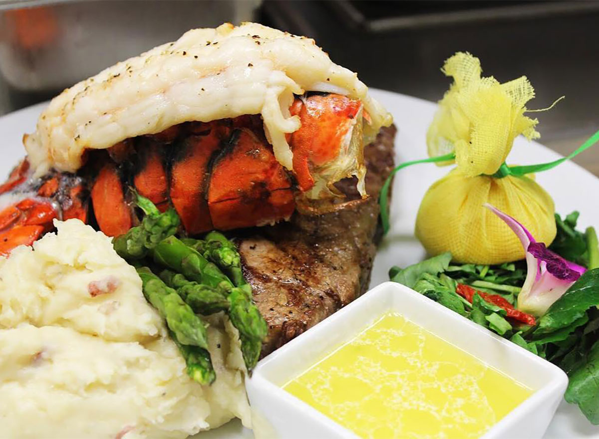 steak topped with lobster tail served with asparagus and mashed potatoes