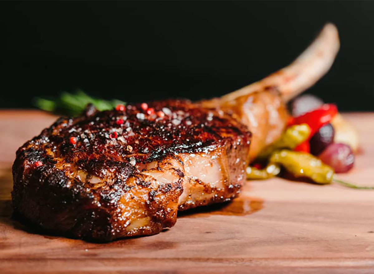 bone in tomahawk ribeye steak on wooden board