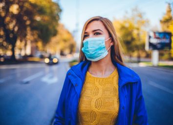 Woman wearing face mask because of air pollution or virus epidemic in the city.